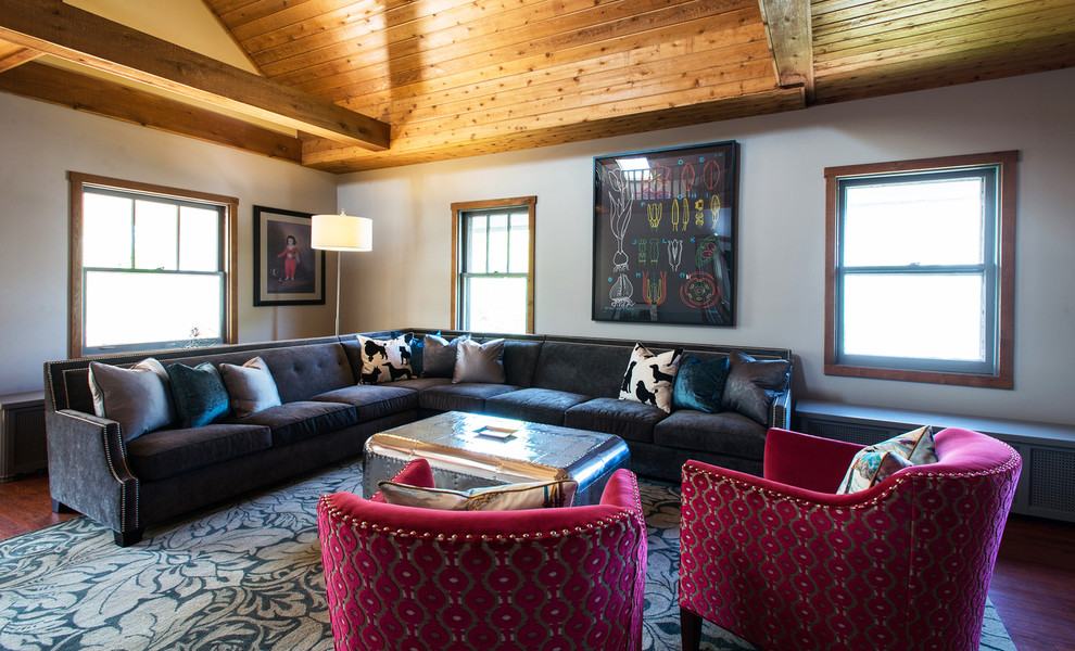 A Poltrona na sala em cor rosa combinado com os tons de marrom tornam essa uma sala de estar sofisticada e confortável